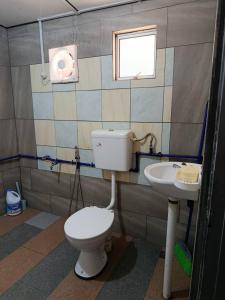 a bathroom with a toilet and a sink at Dongorit Cabin 2 The three rooms in Kampong Kundassan +7 photos