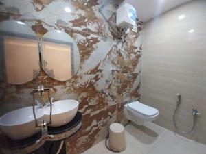 a bathroom with a sink and a toilet and a mirror at Hotel Sea Touch in Digha +6 photos