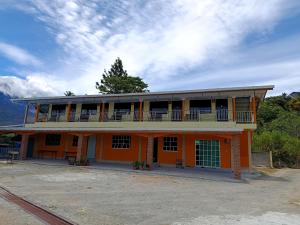 an orange building with a balcony on top of it at Dongorit Cabin 2 The three rooms in Kampong Kundassan