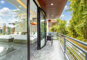 a glass balcony with a bed and a couch at Ruby Mountain View Resort Vang-vieng in Vang Vieng +55 photos