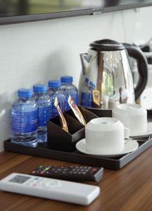 a tray with bottles of water and a remote control at Ruby Mountain View Resort Vang-vieng in Vang Vieng