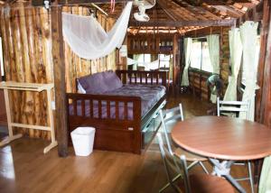 Pokój z łóżkiem, stołem i krzesłami w obiekcie Sunflower Boathouse w Ko Phi Phi