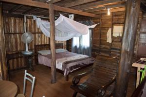 a bedroom with a bed with a hammock and a chair at Sunflower Boathouse in Phi Phi Don