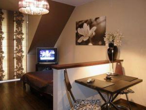 a living room with a table and a television at Apartament 37 Magnolia - Pod Aniołem in Kazimierz Dolny