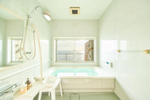 a white bathroom with a tub and a window at Villa Acatella in Awaji +44 photos