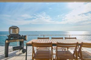 a tv and chairs on a deck with the ocean at Villa Acatella in Awaji