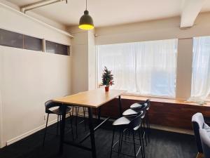 a dining room with a table and chairs and a window at Utopia31 Hostel - formerly Frienz Backpacker in Auckland +17 photos