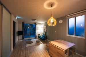 a living room with a wooden table and a pendant light at Matsumoto 101 in Matsumoto