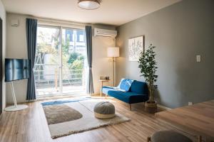 a living room with a blue couch and a large window at Matsumoto 101 in Matsumoto