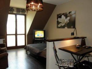 a bedroom with a bed and a table and a television at Apartament 37 Magnolia - Pod Aniołem in Kazimierz Dolny