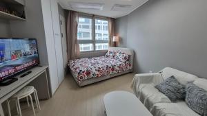 a living room with a couch and a chair and a television at A house with a beautiful sunset in Ansan