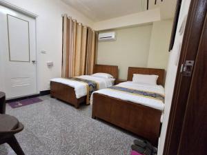a hotel room with two beds and a window at Kinmen Dongshan B&B in Jinning