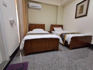 two beds in a small room withermottermott at Kinmen Dongshan B&B in Jinning