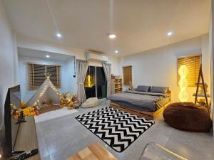 a living room with a bed and a television at Tee Phak CNX Room D in Chiang Mai