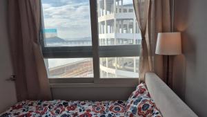 a bedroom with a bed and a large window at A house with a beautiful sunset in Ansan