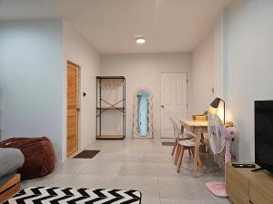 a bedroom with a table and a room with a door at Tee Phak CNX Room D in Chiang Mai
