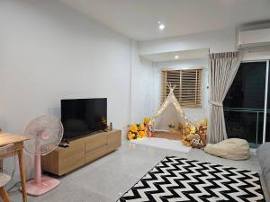 a living room with a tv and teddy bears at Tee Phak CNX Room D in Chiang Mai