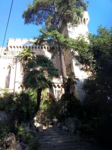 un bâtiment avec des arbres et des escaliers dans un jardin dans l'établissement Villa du Chateau, à Nice
