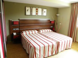 a bedroom with a bed with a wooden headboard at Hotel Noguera El Albir in Albir