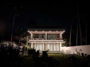 a building with lights on it at night at Sukavi in Paravūr