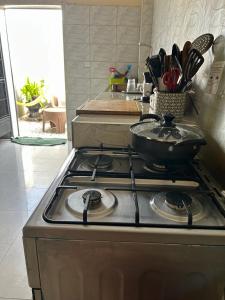 a stove top with a pan on top of it at Chambre avec salle de bain privative proche de la plage et de Saly in Mbour