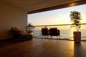 a living room with a view of the ocean at Sukavi in Paravūr