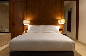 a bedroom with a large white bed with two lamps at Sukavi in Paravūr