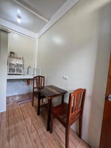 a kitchen with a wooden table and two chairs at Cardo Rooms 2 minutes walk from the beach in General Luna +4 photos