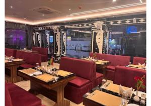 a restaurant with red chairs and tables in a room at Hotel Sea Touch in Digha