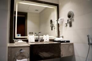 een badkamer met een wastafel en een grote spiegel bij Valy Hotel in Al Madinah +38 foto's