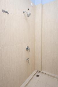 a shower with two faucets in a bathroom at Mekarsari Hotel By ARBA in Tjipitjung Tiga +35 photos