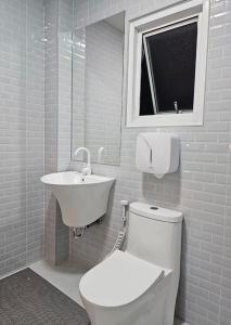 a bathroom with a white toilet and a sink at Tee Phak CNX Room D in Chiang Mai