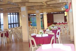 een feestzaal met tafels en stoelen met paarse tafelkleden bij Mountain Pine Breeze in Sampong