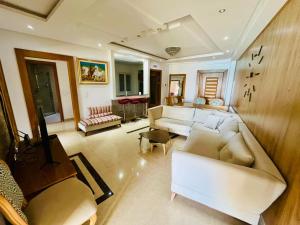 a living room with a white couch and chairs at Espadon Apartment in Mahdia