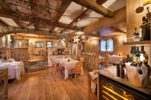 a restaurant with tables and chairs in a room at Hotel Astra in Livigno