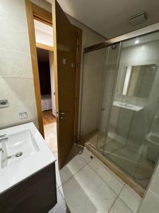 a bathroom with a glass shower and a sink at Murcia in Rabat +4 photos
