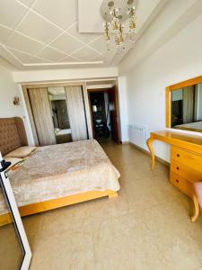 um quarto com uma cama e uma escrivaninha em Espadon Apartment em Mahdia