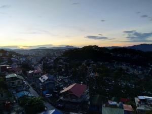 een uitzicht op een stad met de zonsondergang op de achtergrond bij Mountain Pine Breeze in Sampong