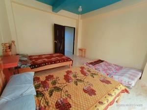 een kamer met 2 bedden en een tafel en een bed sidx sidx sidx bij Mountain Pine Breeze in Sampong