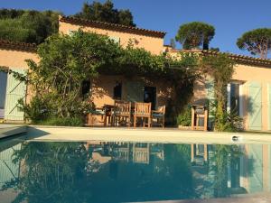 a house with chairs and a swimming pool at Villa "La vie est belle...!" in Cavalaire-sur-Mer