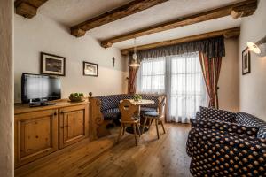 Residence Vila في كولفوسكو: غرفة معيشة مع كنب وطاولة مع تلفزيون