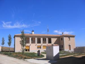 a large white building with a flag on top of it at Hostal Moratinos in Moratinos