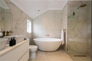 a bathroom with two sinks and a tub and a toilet at Abalone Hotel & Villas 2 Bedroom Apartment in Paternoster