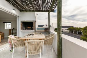 a patio with a table and chairs on a balcony at Abalone Hotel & Villas 2 Bedroom Apartment in Paternoster
