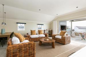 a living room with wicker chairs and a table at Abalone Hotel & Villas 2 Bedroom Apartment in Paternoster
