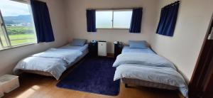 En eller flere senge i et værelse på Guesthouse ONAKA 巡礼の宿 Pilgrim's Inn