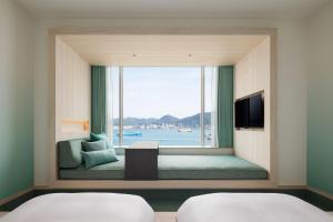 a room with a window with a view of the water at RISONARE Shimonoseki in Shimonoseki +25 photos