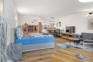 a living room with a blue bed and a kitchen at Altes Holzboot in Steinhude