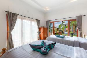 a bedroom with two beds and a window at Sekumpul Guest House in Sudaji
