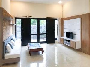 a living room with a couch and a tv at Telaga Villa Siki in Mantaak